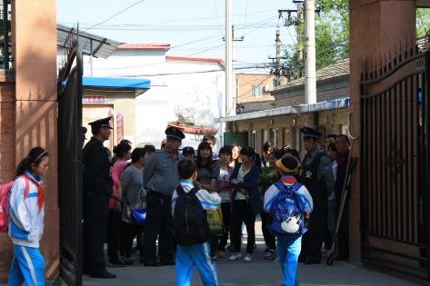 Forældre venter uden for skoleporten i Beijing